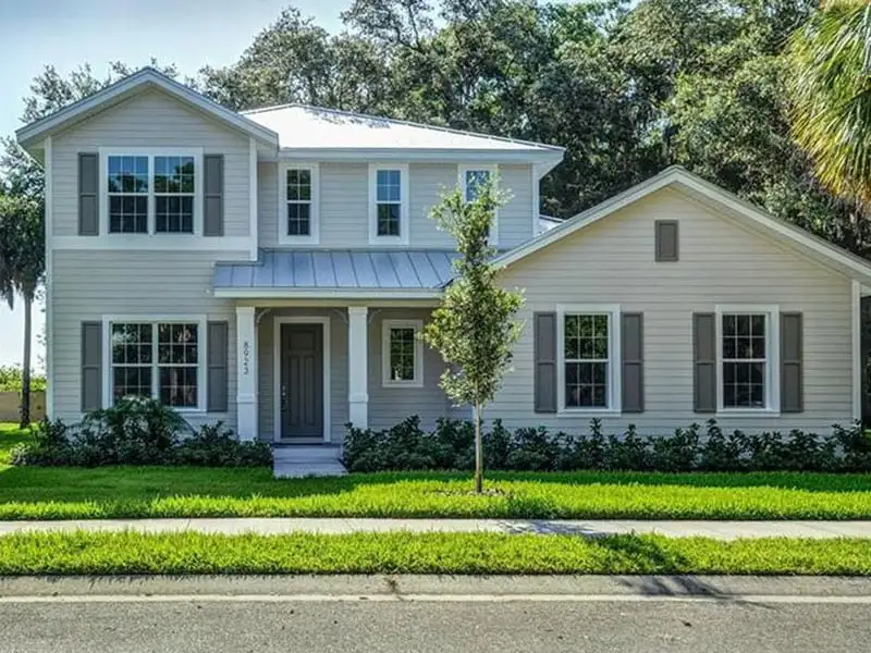Standing seam metal roof installed on a Tampa home with siding and landscaping