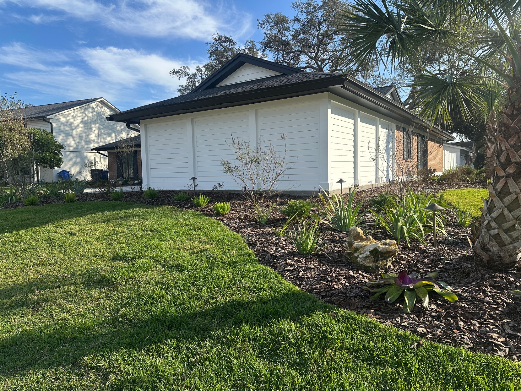 Modernized Carrollwood home exterior with white lap siding, dark trim, and fresh landscaping