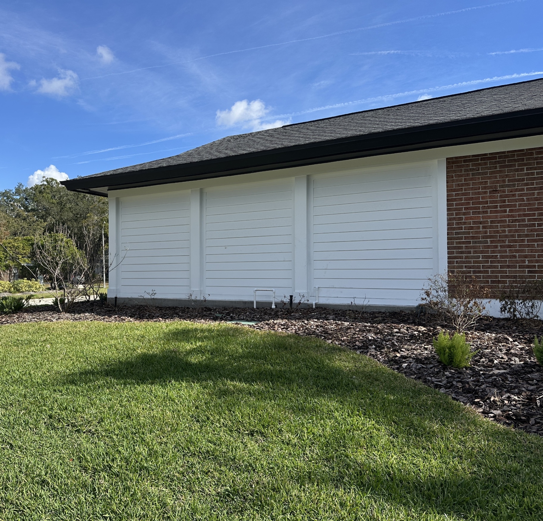 Completed siding upgrade on a Carrollwood home — white lap siding with new roof